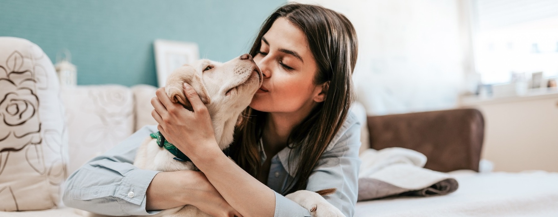 a woman lying on a bed with a dog